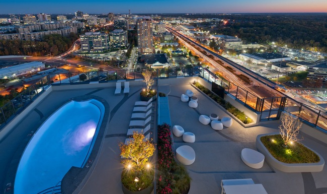 rooftop patio with pool and view of a city
