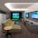 a room with a tv couch and golf simulator